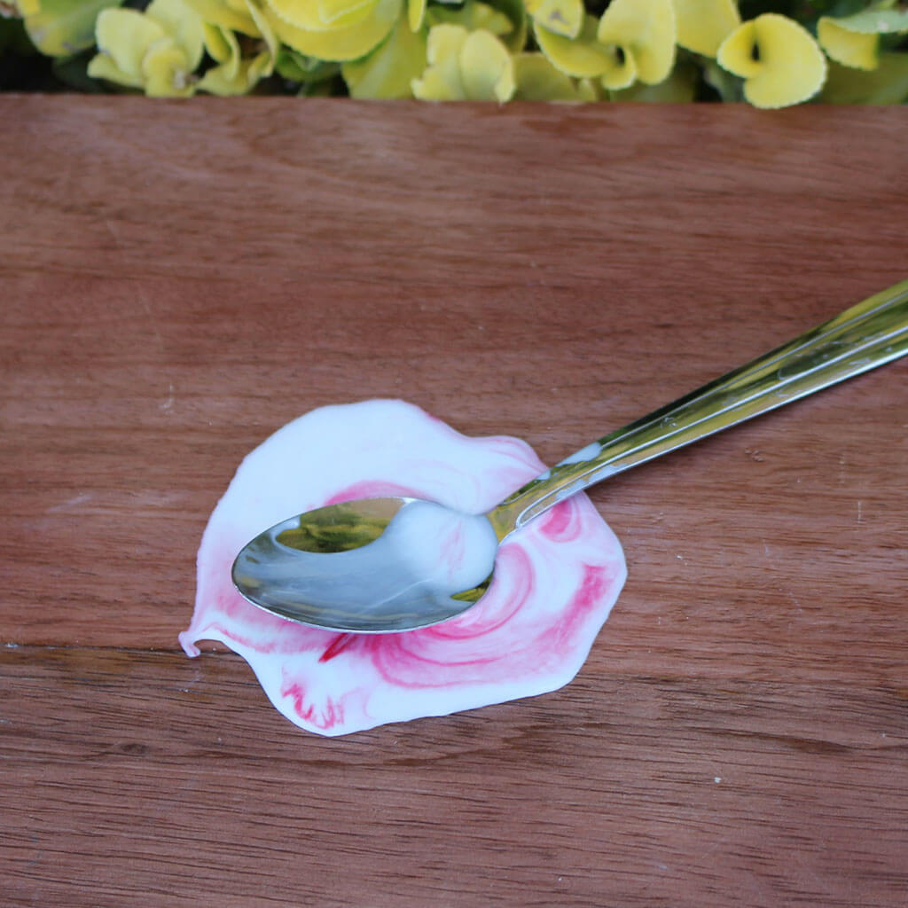 Melting Ice Cream Spoon With Strawberry Sauce